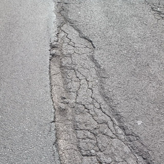 Buche e asfalto sconnesso. Strada insidiosa per andare a Dolcedo o Isolalunga