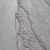 Buche e asfalto sconnesso. Strada insidiosa per andare a Dolcedo o Isolalunga