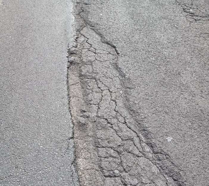 Buche e asfalto sconnesso. Strada insidiosa per andare a Dolcedo o Isolalunga