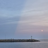 Luna e raggi crepuscolari regalano uno spettacolo nel cielo di Diano Marina