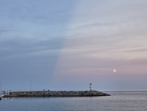 Luna e raggi crepuscolari regalano uno spettacolo nel cielo di Diano Marina