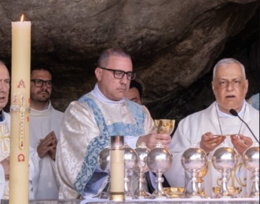 A sinistra il diacono Alex Dellerba durante la celebrazione nella Grotta di Massabielle