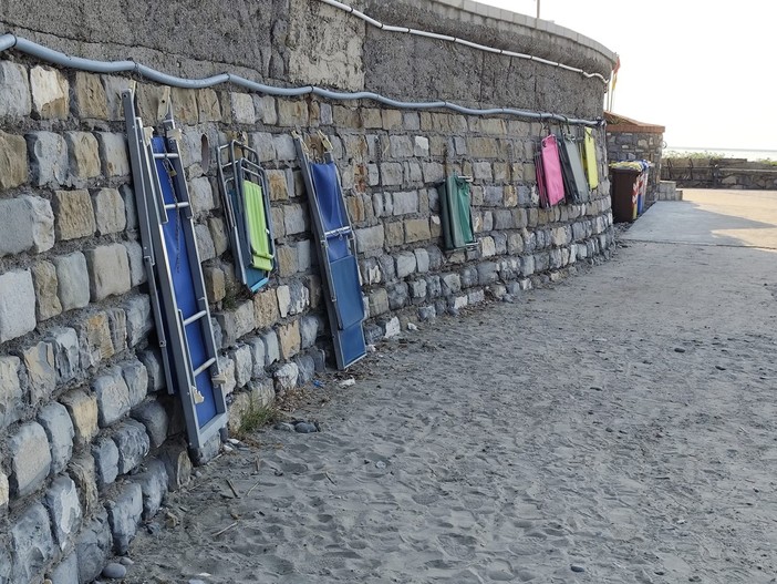 Degrado e pericolo alla Foce di Porto Maurizio: sedie e lettini incatenati al muro nonostante la promessa dell’assessore di rimozione Degrado e pericolo alla Foce di Porto Maurizio: sedie e lettini incatenati al muro nonostante la promessa dell’assessore di rimozione