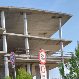 Lo scheletro di una palazzina del porto, simbolo di un porto incompiuto da 15 anni